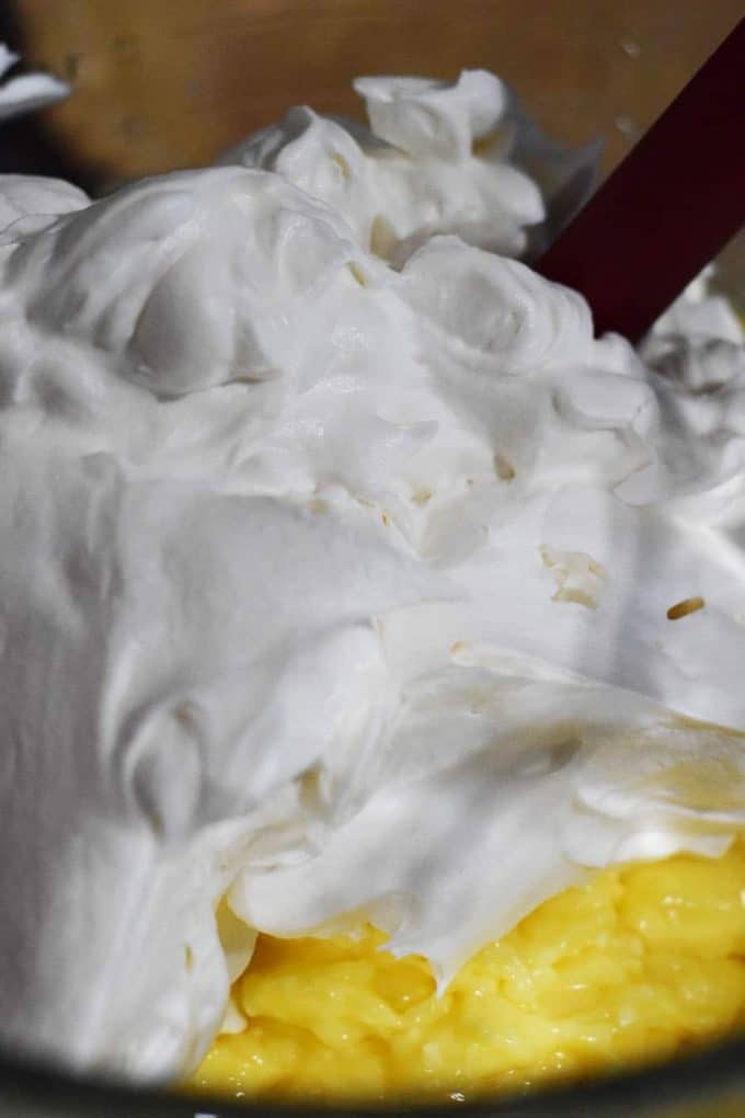 folding together the whipped topping and coconut cream pudding for the coconut cream pie filling