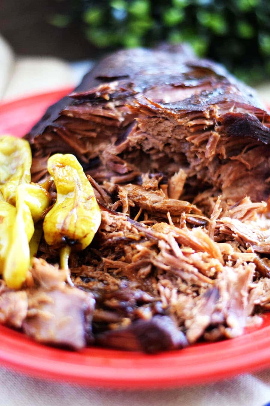shredded beef and cooked pepperochinis from this slow cooker mississippi pot roast recipe