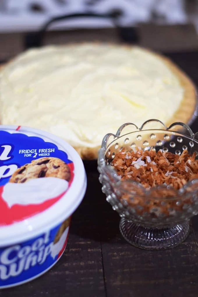 Coconut Cream Pie with Container of Cool Whip and Toasted Coconut in a bowl 