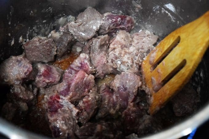 a closeup of chopped beef tips sautéing in the instant pot for this pressure cooker beef tips recipe