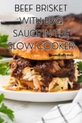Beef brisket with BBQ sauce in the slow cooker plated with coleslaw on a bun.