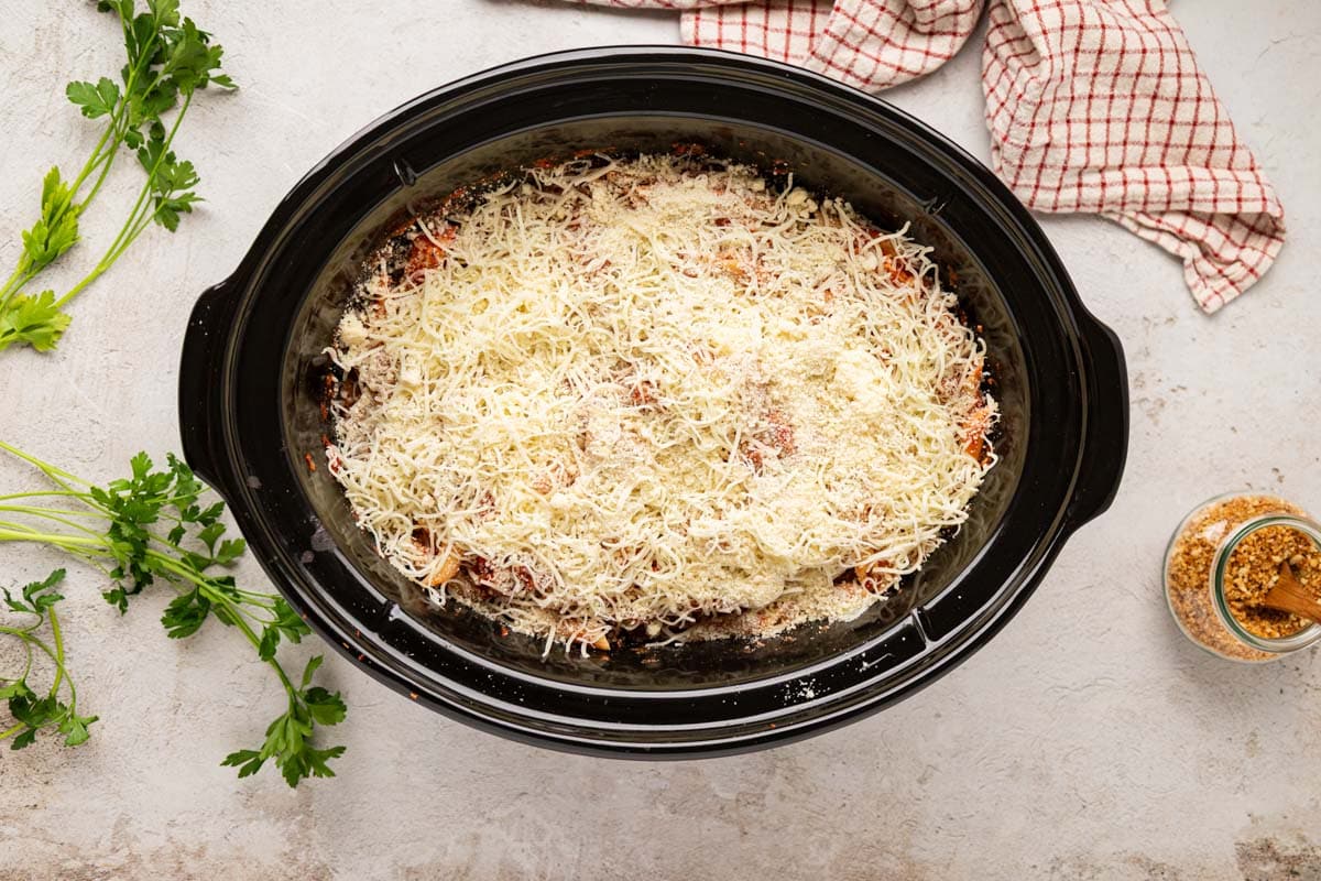 Cheeses added to the top of the chicken parmesan pasta in the crock pot.