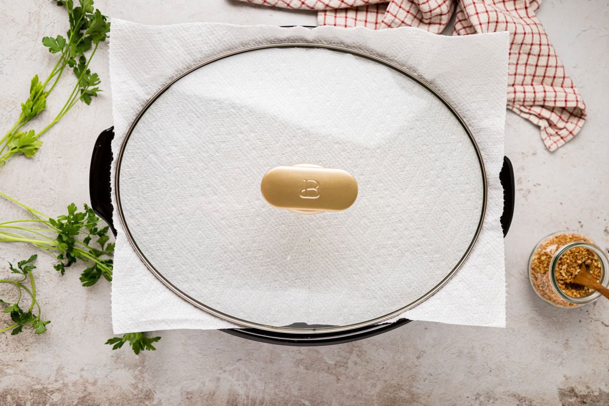 A paper towel place under the lid of the slow cooker to finish melting cheese on top.
