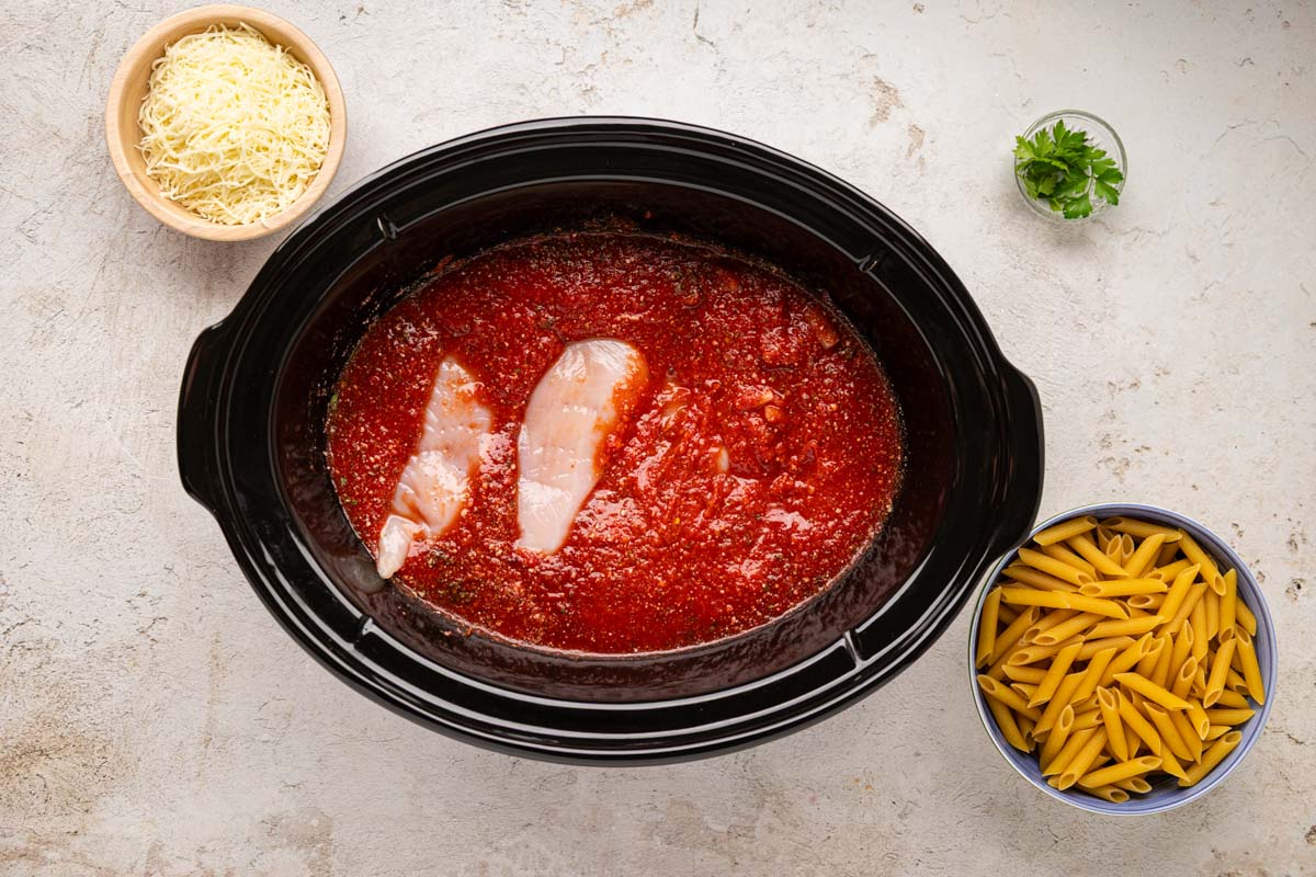 Chicken added to the sauce in the slow cooker.