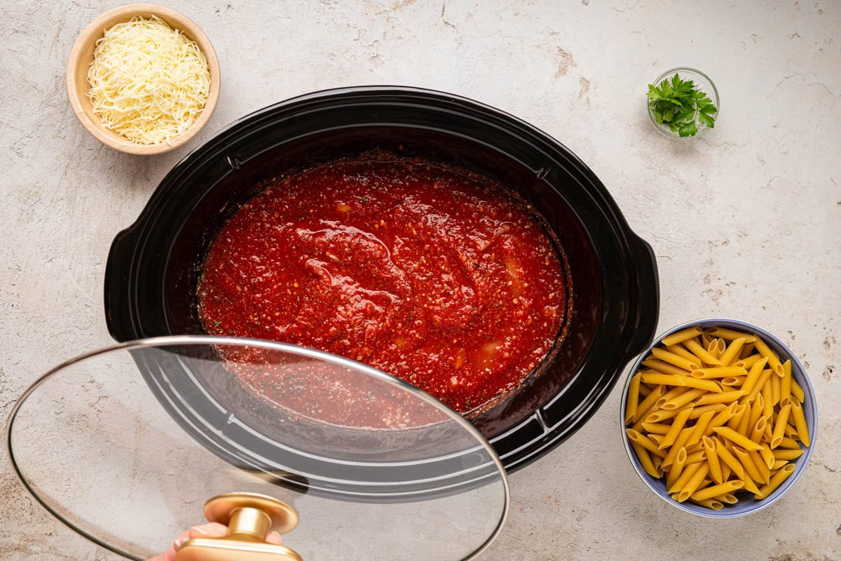 Adding lid to the slow cooker to cook.