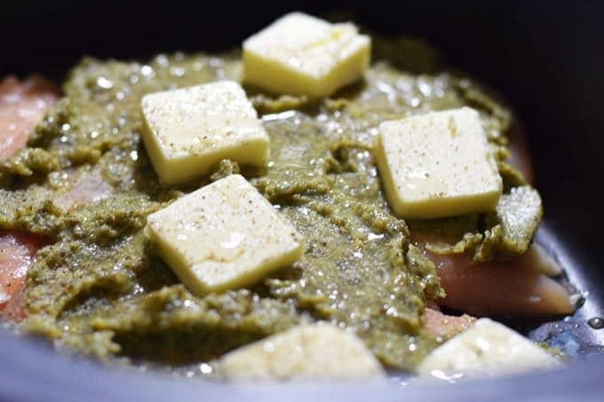 a closeup of pesto and butter for this slow cooker cheesy pesto chicken pasta