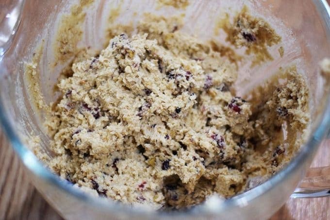 a glass stand mixer bowl filled with the dough for candied cranberry walnut oatmeal cookies