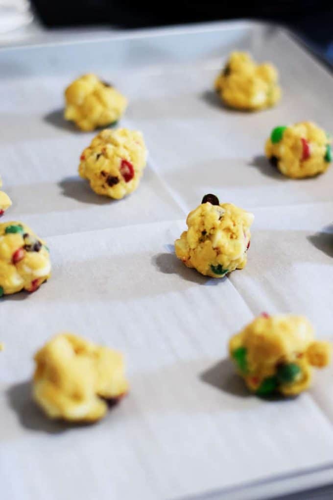 balls of dough on a prepared baking sheet to make these santa\'s chocolate chip cookies