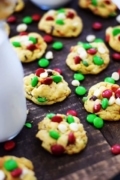 Several Christmas chocolate chip cookies with red, white, and green mini m&m candies, aka Santa's chocolate chip cookies