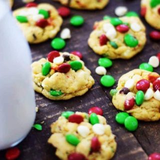 Several Christmas chocolate chip cookies with red, white, and green mini m&m candies, aka Santa's chocolate chip cookies