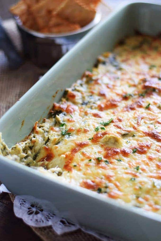 A large white serving dish filled with this Slow Cooker Spinach and Artichoke Dip recipe