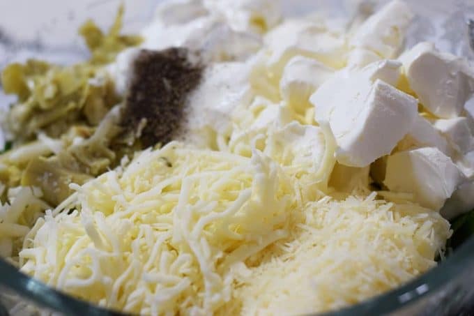 the cheese and other ingredients needed to make this slow cooker spinach and artichoke dip