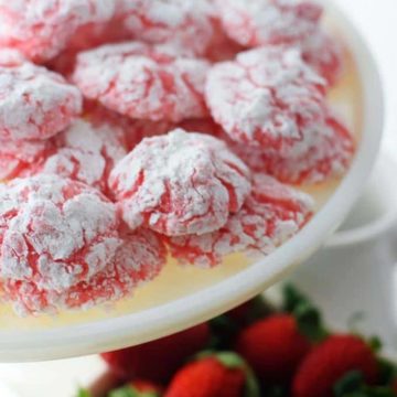 a white serving platter filled with strawberry cake mix cookies aka strawberry crinkle cookies