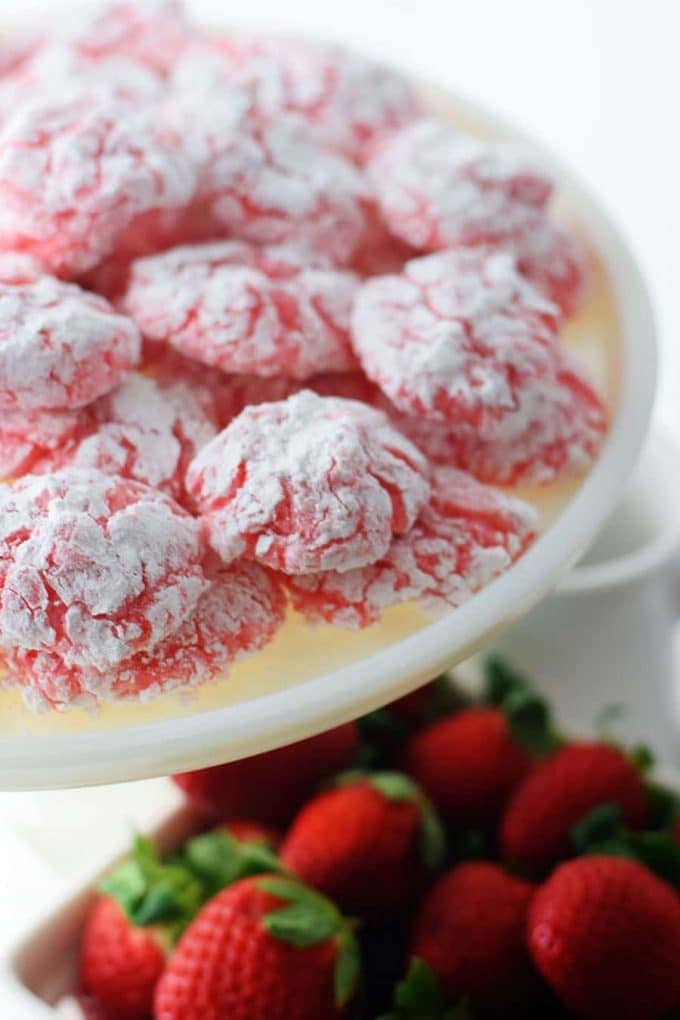 a white serving platter filled with strawberry cake mix cookies aka strawberry crinkle cookies