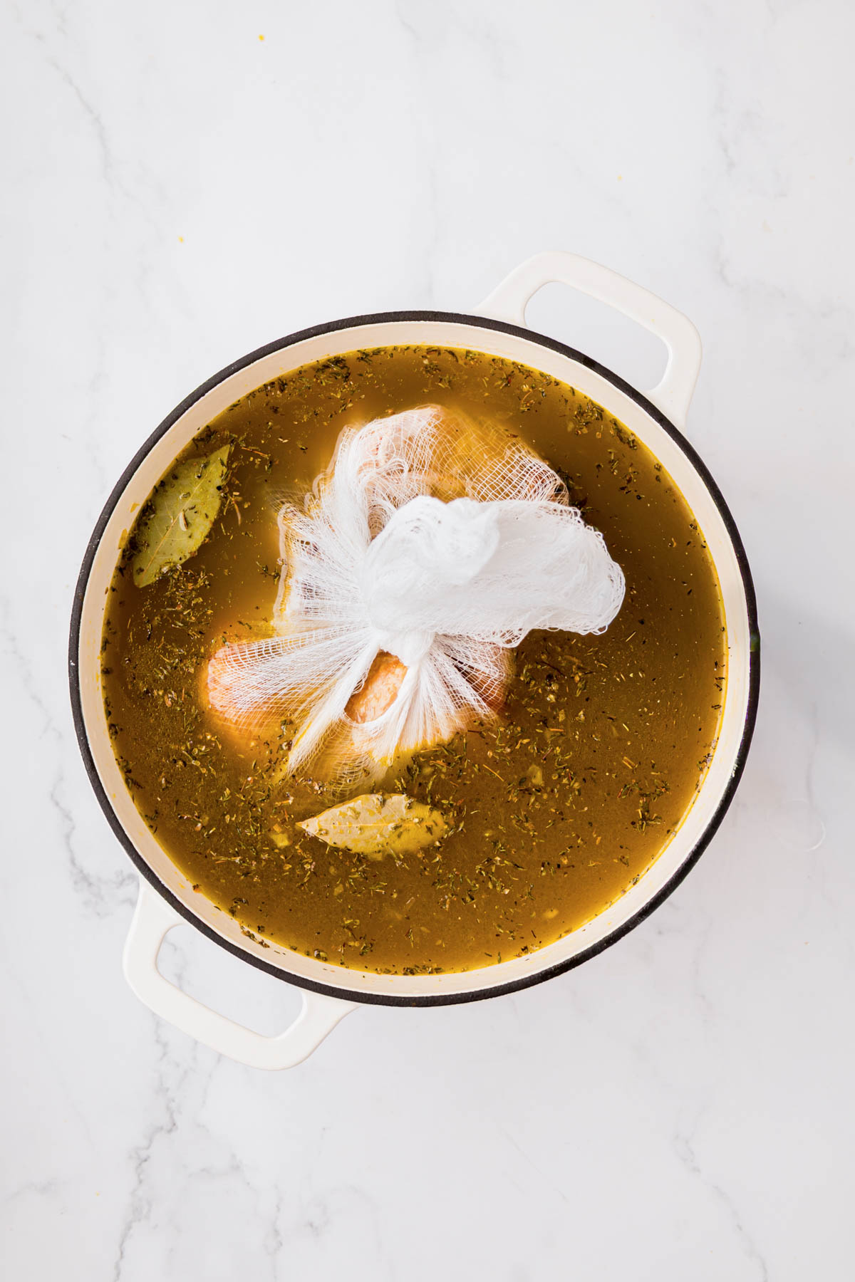 Bay leaf, spices added and chicken carcass to the soup pot with broth.