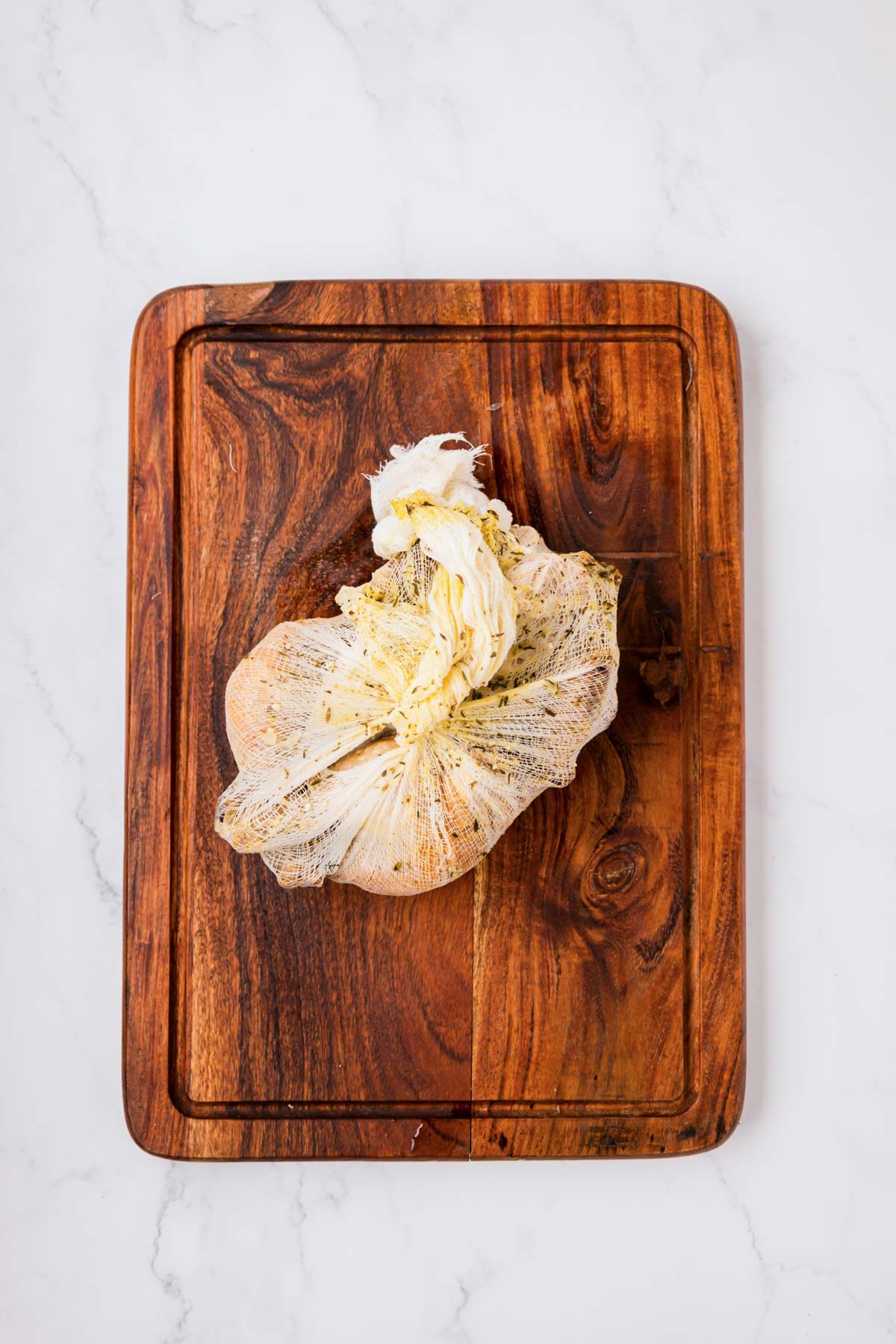 Wrapped chicken carcass removed from soup pot and placed on cutting board.