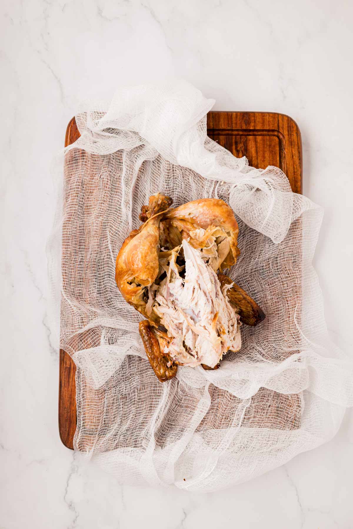 The rest of the rotisserie carcass placed on a cheese cloth to tie up.