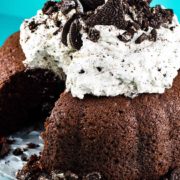 a close-up of chocolate cake with whipped oreo icing with a slice missing