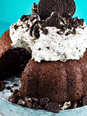 a close-up of chocolate cake with whipped oreo icing with a slice missing