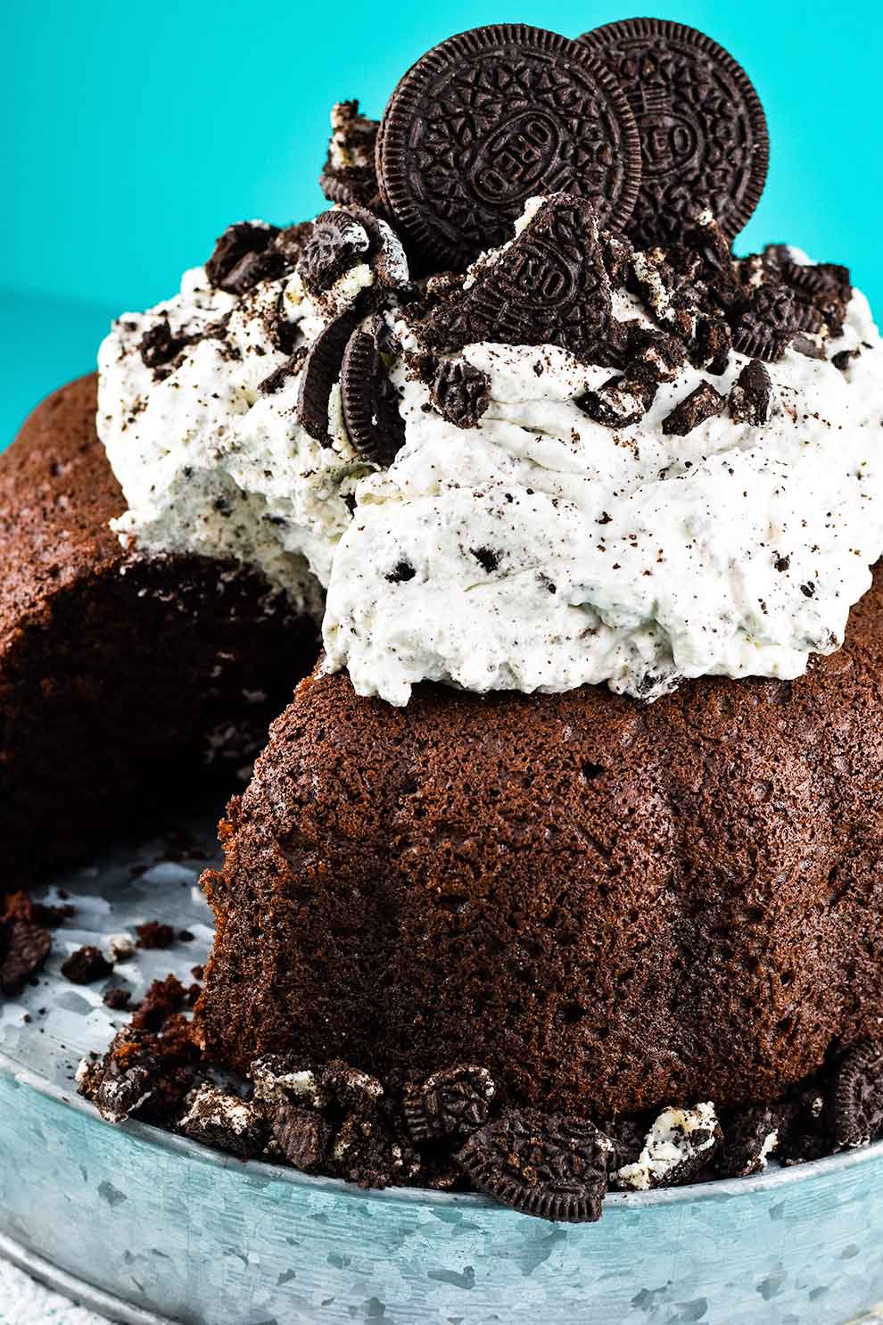 a close-up of chocolate cake with whipped oreo icing with a slice missing 