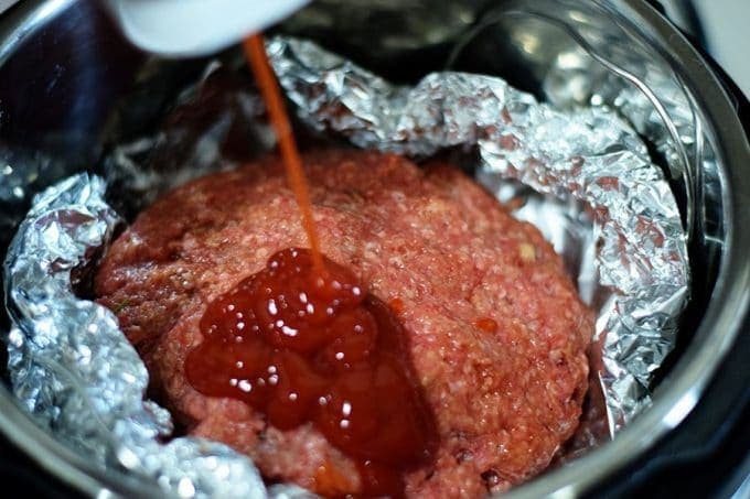 a closeup of this raw ground beef mixture with ketchup for the instant pot meatloaf and potatoes recipe