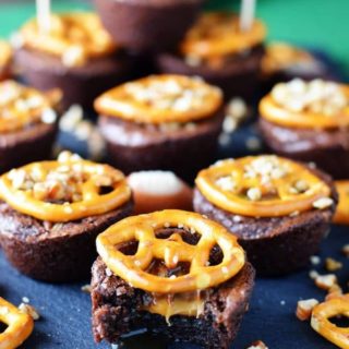 a closeup of miniature turtle brownies topped with salted pretzels to make these touchdown turtle brownie bites as the perfect game day food