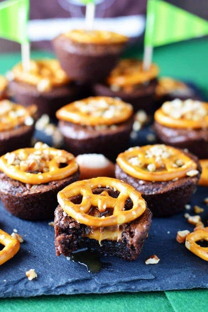 a closeup of miniature turtle brownies topped with salted pretzels to make these touchdown turtle brownie bites as the perfect game day food