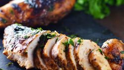 Best Chicken Marinade - Grilled Chicken on a black tray with parsley.