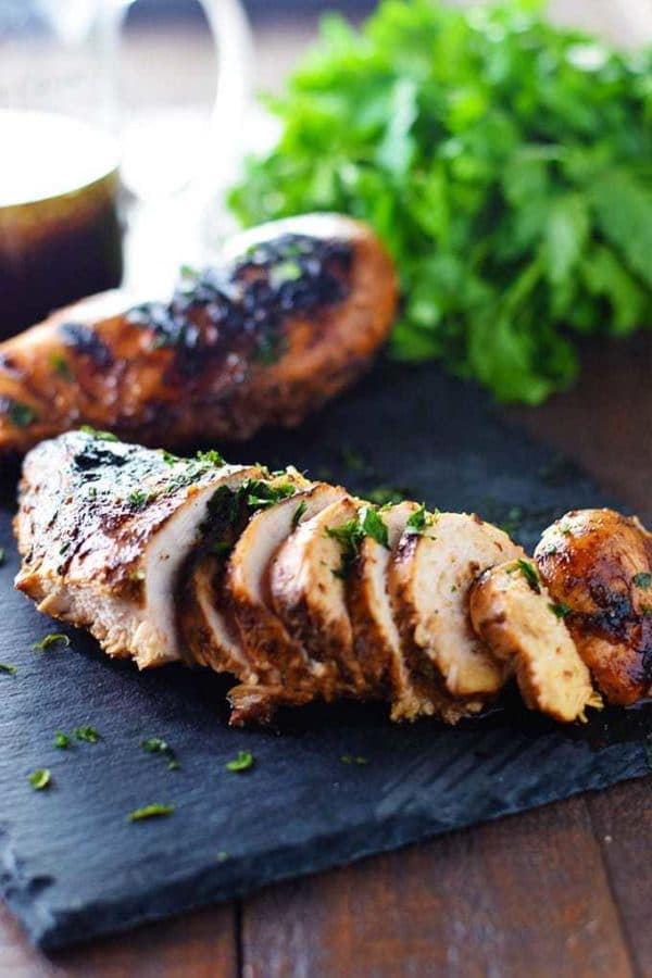 Best Chicken Marinade - Grilled Chicken on a black tray with parsley.