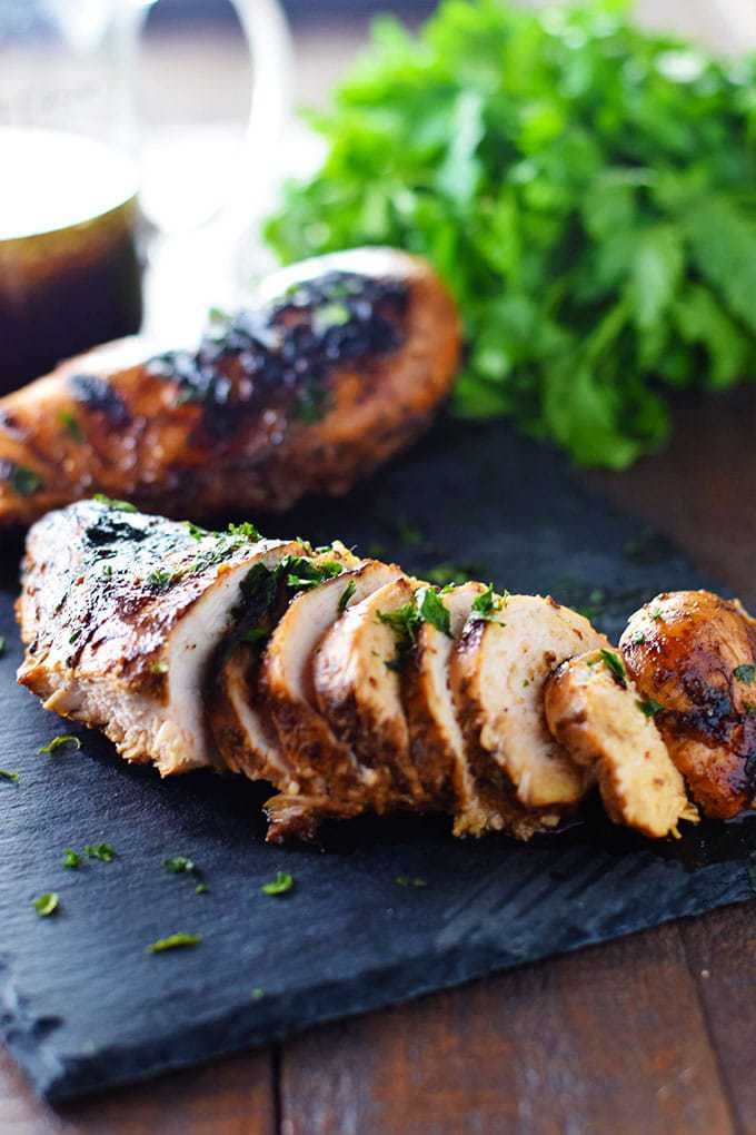 Best Chicken Marinade - Grilled Chicken on a black tray with parsley. 