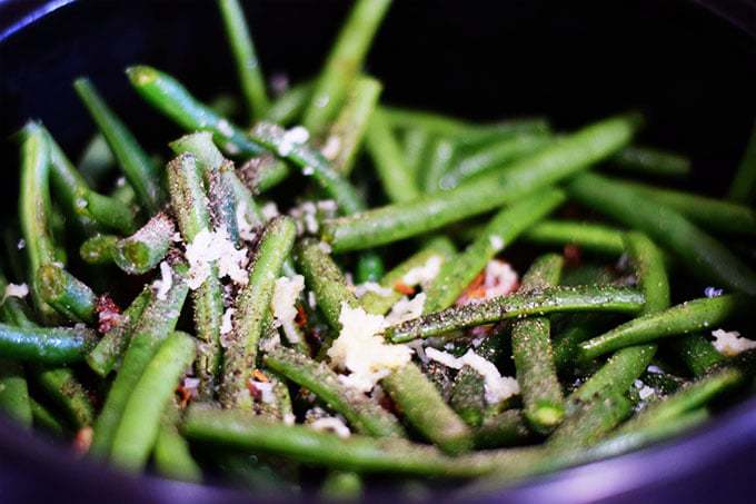 a closeup of fresh green beans seasoned with salt, pepper, and garlic