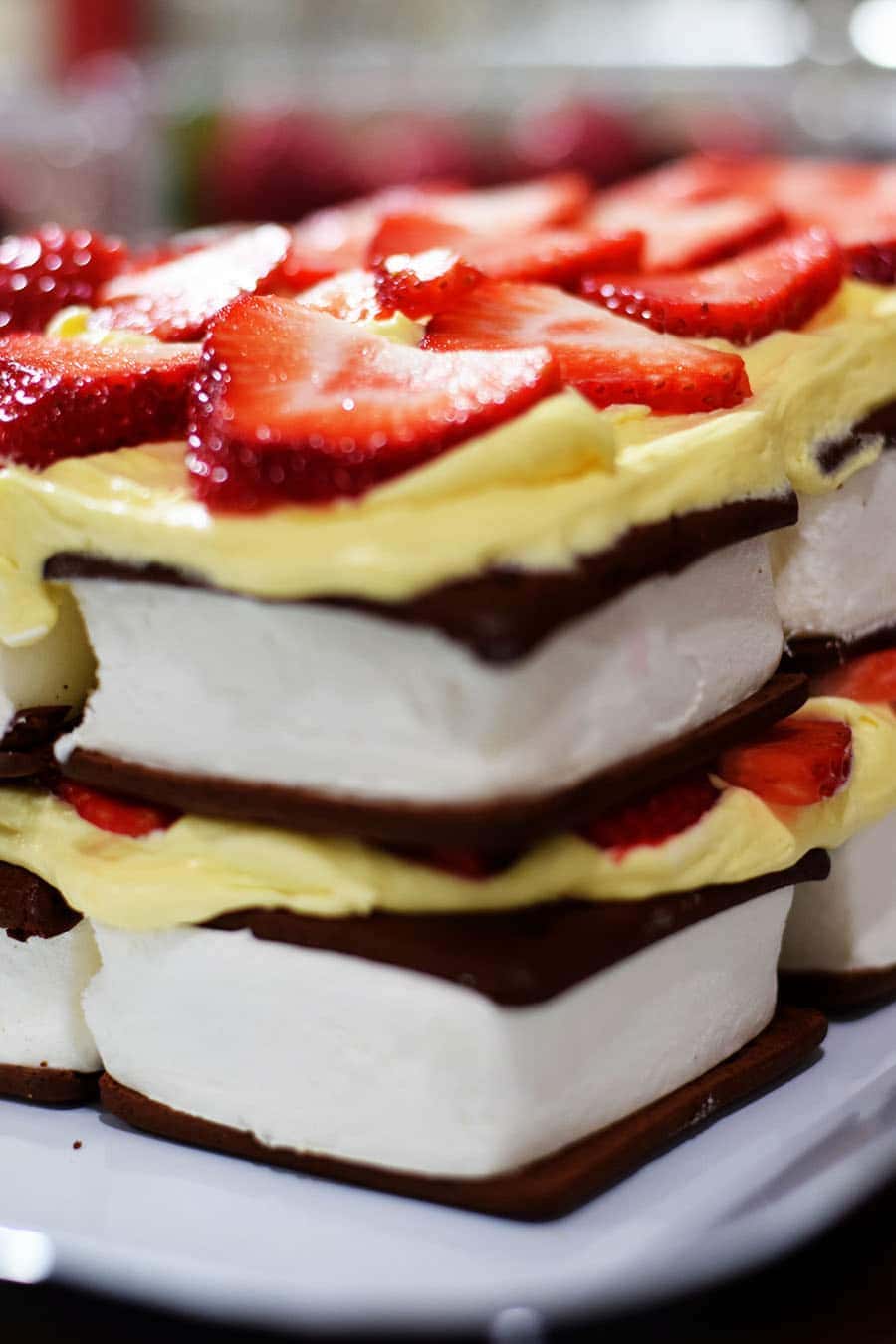 a side view of this strawberry ice cream cake layers with ice cream sandwiches, pudding, and sliced strawberries