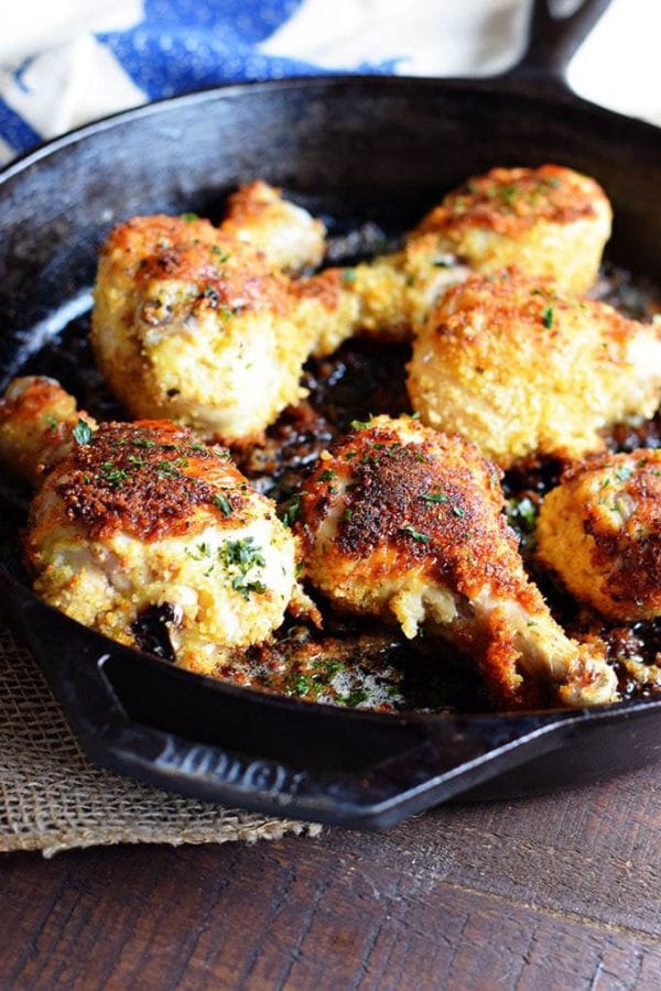 Panko Crusted  Oven Fried Chicken Drumsticks in a Cast Iron Skillet on a wooden table.