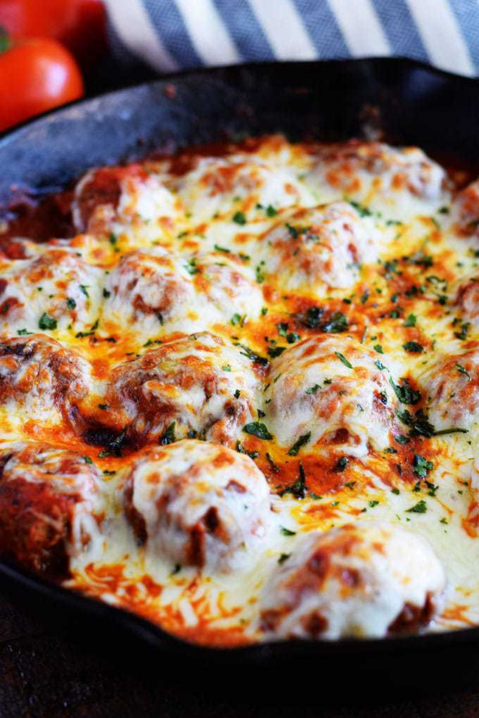 A closeup of these cheesy skillet meatballs in marinara sauce