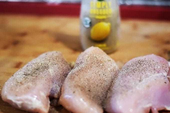 three raw chicken breasts seasoned with lemon pepper for this skillet lemon chicken and potatoes recipe