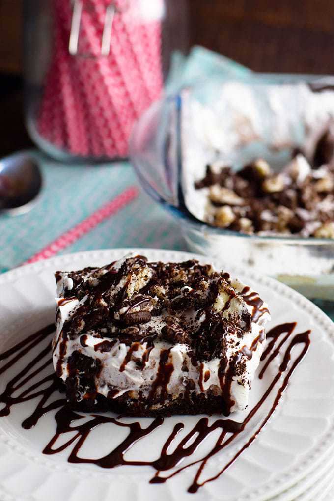 Slice of Oreo Brownie Poke Cake on White Plates