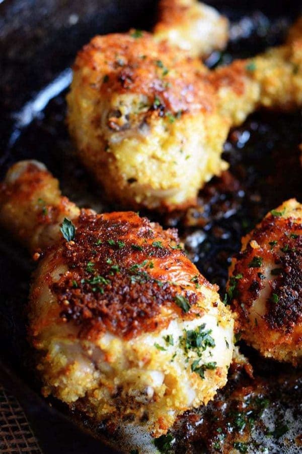 Up close photo of oven fried chicken drumstick in a cast iron skillet.