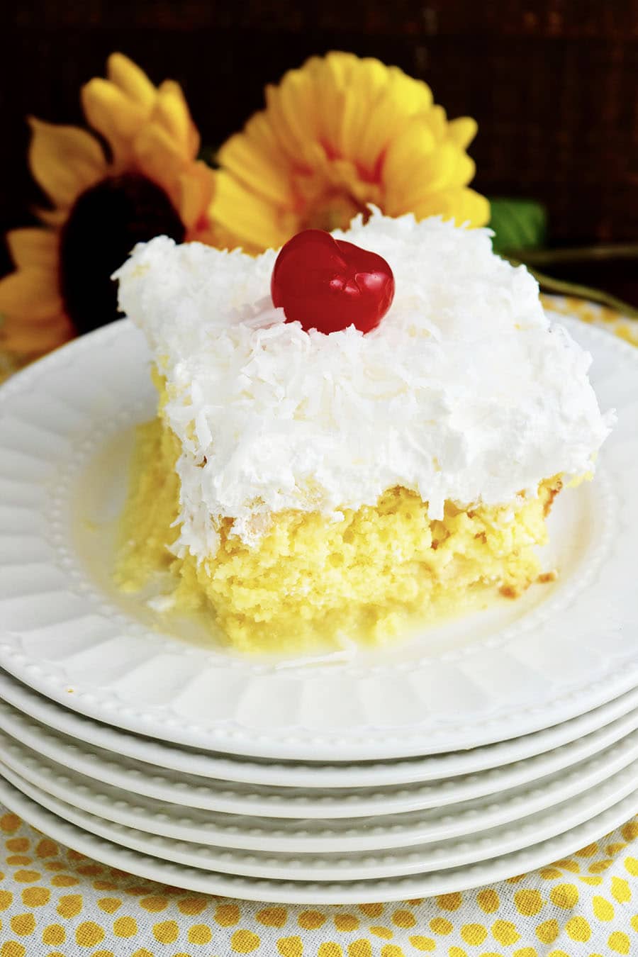 Slice of Pina Colada Poke Cake on white plate