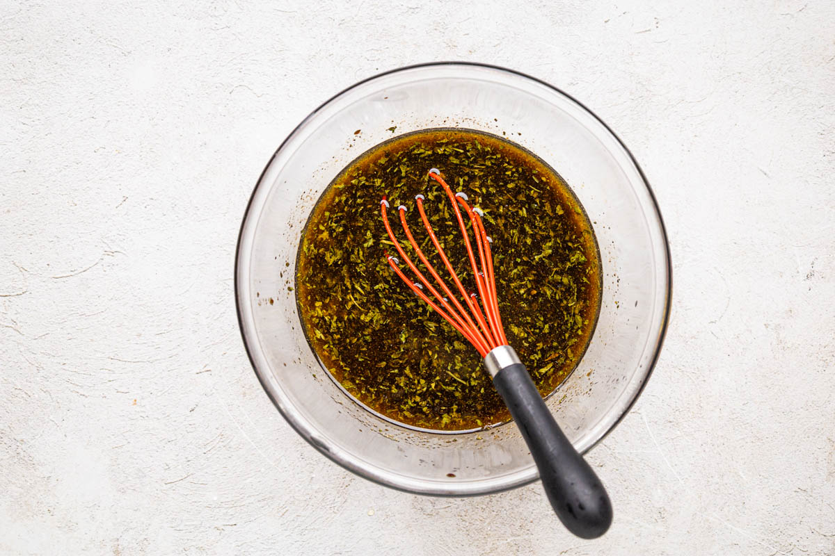Grill chicken marinade whisked together in a clear bowl.