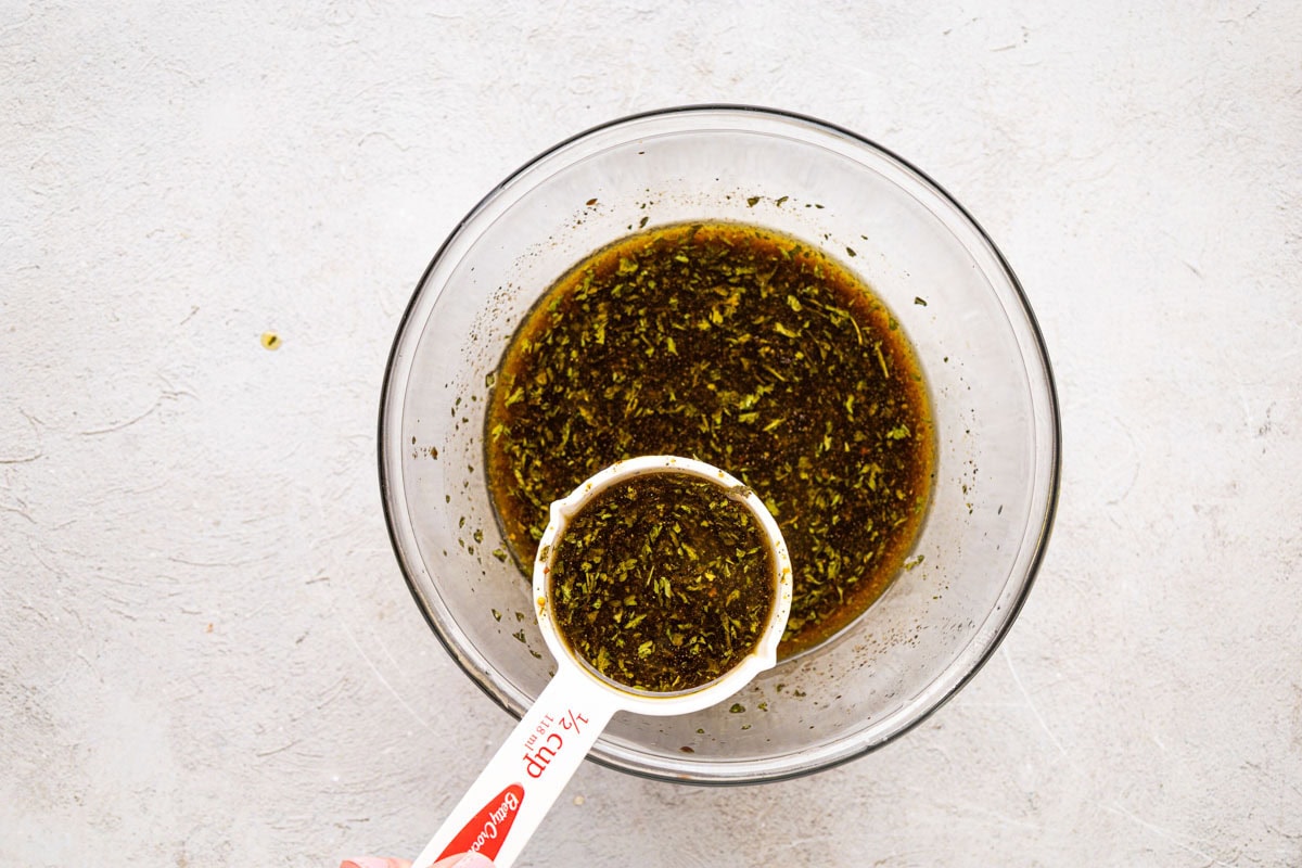 Removing a portion of marinade from bowl.