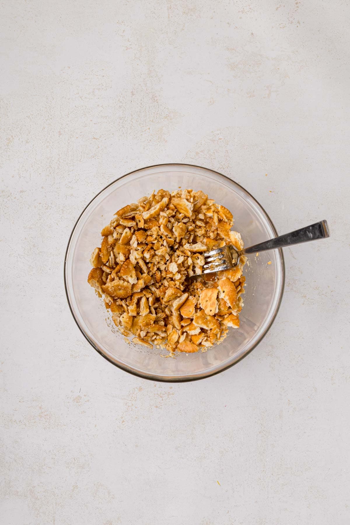 Crushed crackers and butter mixed together in a bowl.