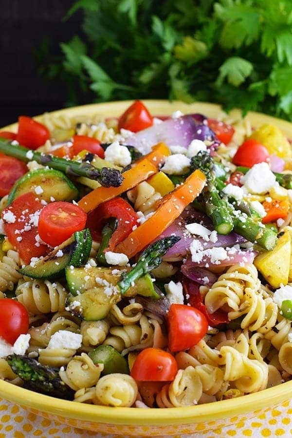 an overhead shot of this colorful grilled summer vegetable pasta salad recipe with crumbled cheese, rotini noodles, and chopped veggies