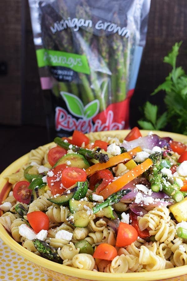 an overhead shot of this colorful grilled summer vegetable pasta salad recipe with crumbled cheese, rotini noodles, and chopped veggies