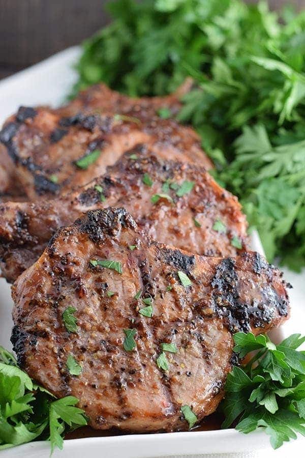 a closeup of these grilled sweet and spicy mustard pork chops garnished with chopped parsley
