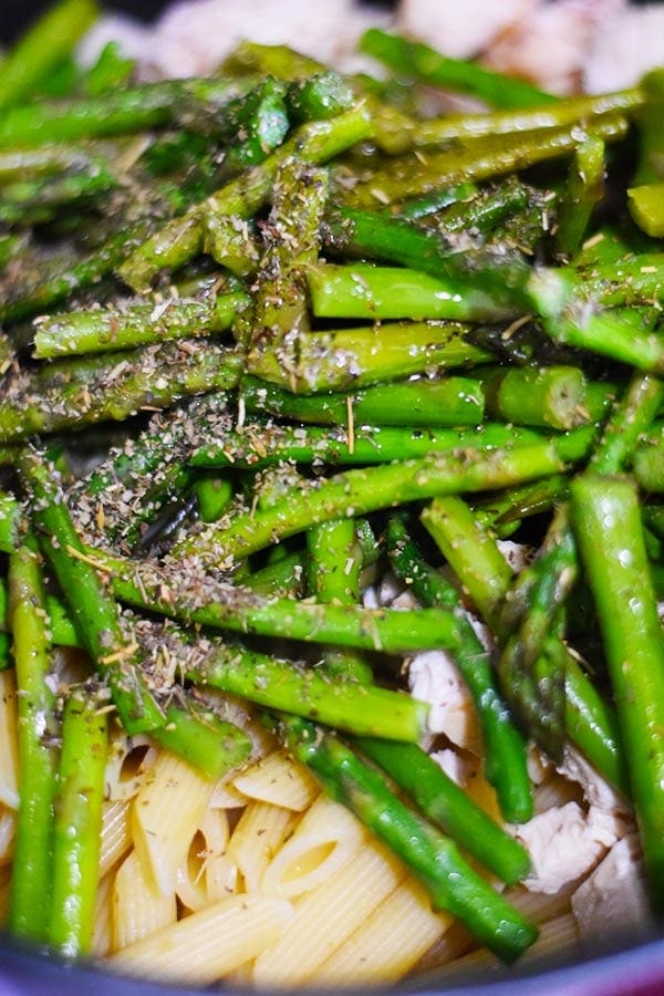 a closeup of bright green asparagus seasoned with pepper and dry spices to make this cheesy chicken asparagus pasta bake recipe