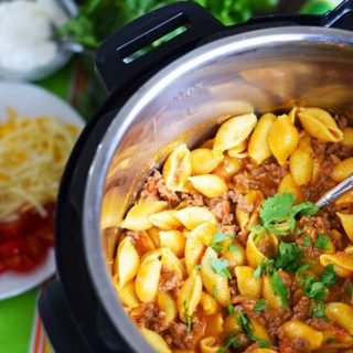 an overhead shot of this instant pot taco pasta inside the pressure cooker insert garnished with chopped parsley