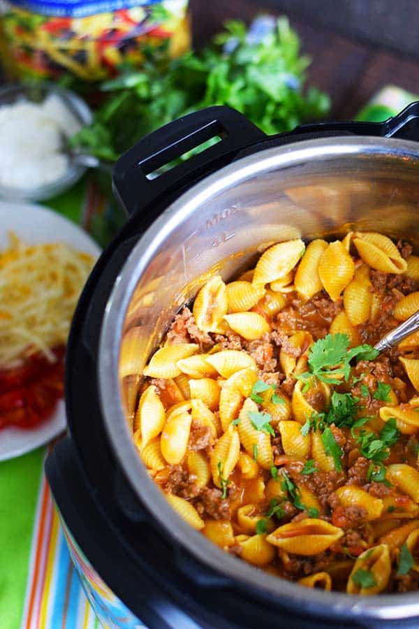 an overhead shot of this instant pot taco pasta inside the pressure cooker insert garnished with chopped parsley