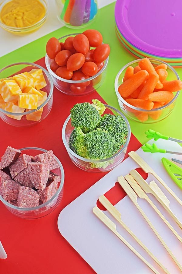 salami babs ingredients like wooden skewers, baby carrots, broccoli florets, cheese cubes, cubed salami, and cherry tomatoes for salami kebabs aka salami skewers
