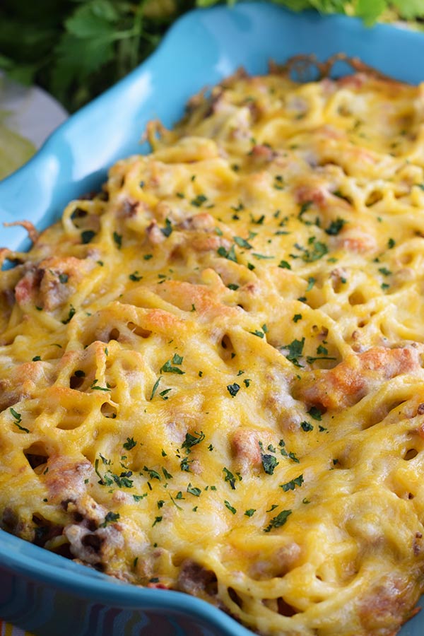an overhead view of this taco spaghetti bake topped with melted cheese and chopped parsley