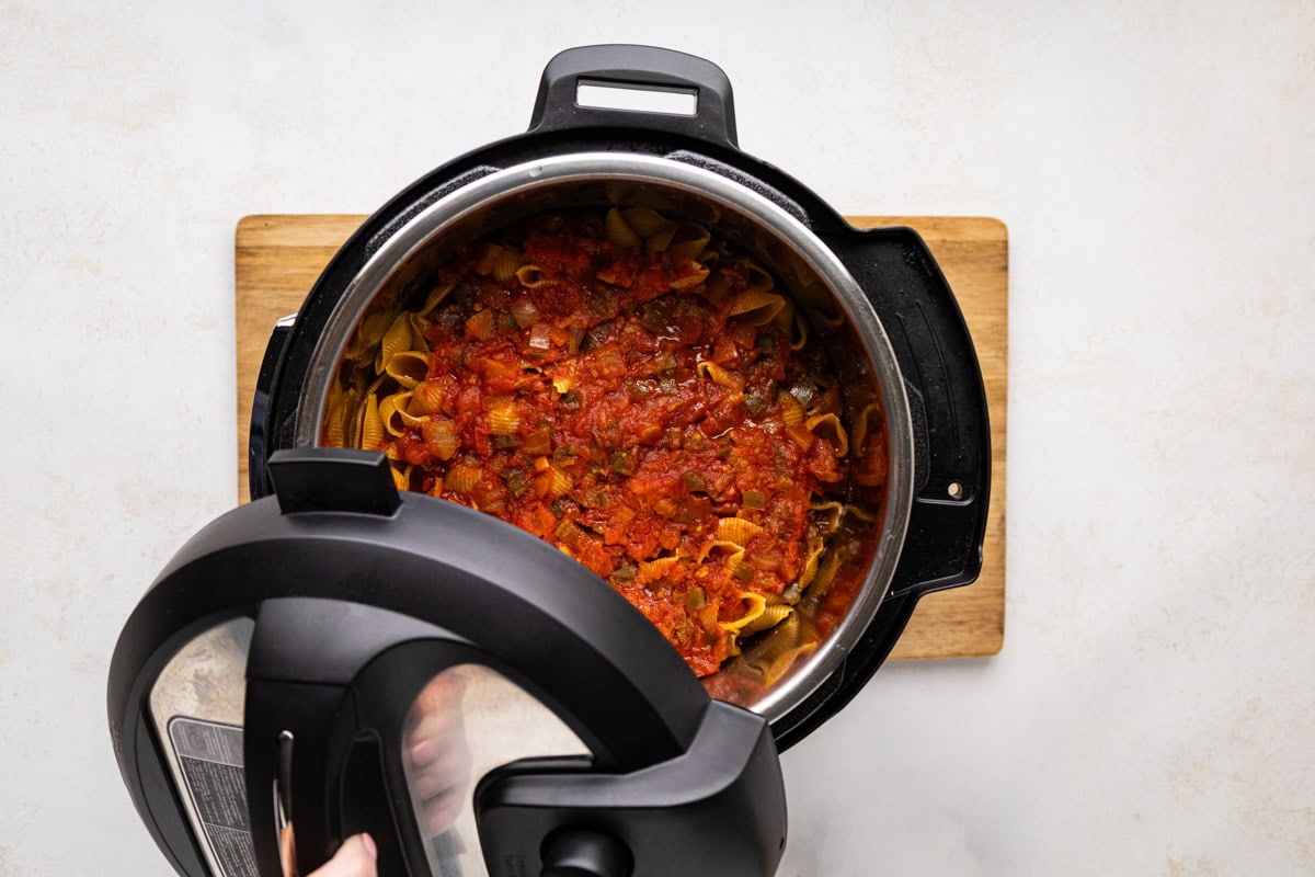 Removing the lid from the instant pot after the pressure has released.